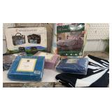 Clear tub of queen sheets, comforter, luggage set