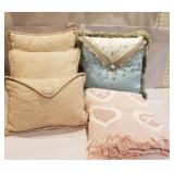 4 decorative pillows and a lap blanket