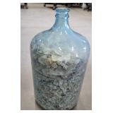 Huge jar of seashells with a bluish tint