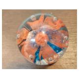 Orange flower with blue paperweight
