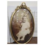 Curved bowed glass baby photo in ornate frame