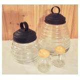 Two beehive shaped lidded glass jars and pair of