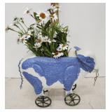 Tin cow on wheels with flowers