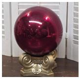 Red glass gazing ball on base