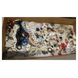 Flat of necklaces, earrings, pins, and more.