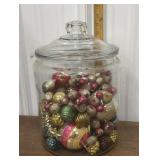 Glass apothecary jar full of old glass ornaments
