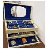 Jewelry box filled with pins, rings, and