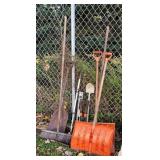 Pile of yard tools, snow shovels, brooms,