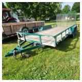 Tandem axle flatbed utility trailer with green ste