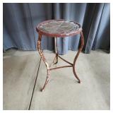 Charming three-legged metal stool or end table fea