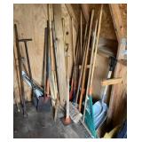 Group of long handle tools right side of shed