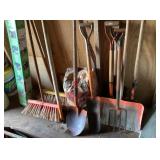Group of long handle tools etc. left side of shed