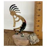 Kokopelli figure mounted on stone