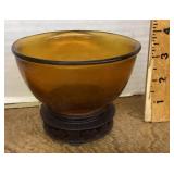 Amber glass bowl set in wooden stand