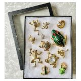 12 costume jewelry frog brooches in riker box