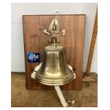 Brass bell mounted on board with shark teeth