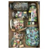 4 glass jars filled with buttons and spools