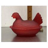 Frosted red glass hen on a nest