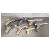 Box of vintage air guns, cap guns, and prop gun