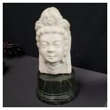 Carved stone Buddha bust on a marble base