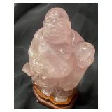 Pink quartz laughing Buddha on wood stand