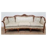 Victorian-style carved wood upholstered sofa