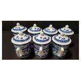 Group of blue and white ceramic tea mugs with lids