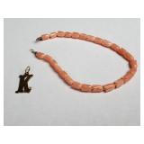 14k gold "K" pendant with diamond and pink coral