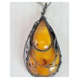 Silver necklace with an amber pendant set in