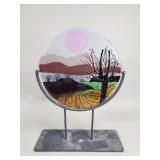 Signed fused glass art mounted on a metal stand
