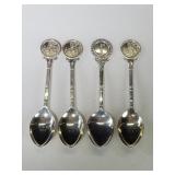 Four silver golf- themed souvenir spoons