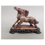 Vintage carved jadeite horse sculpture on wood