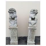 Pair of cement foo dog statues with floral pillars