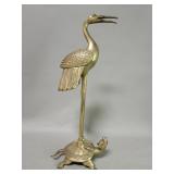 Vintage brass crane standing on a tortoise