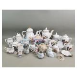 Group of porcelain and ceramic teapots, cream a