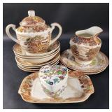 Group of ceramic saucers, creamer, sugar, and a