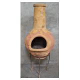 Vintage terracotta outdoor chiminea on metal stand