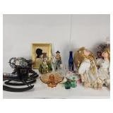 Porcelain dolls, vintage glass bottles, brass