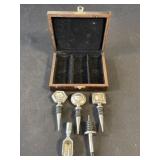 Set of metal bottle stoppers in wood case