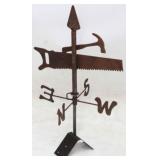 Rusty metal weathervane with tools