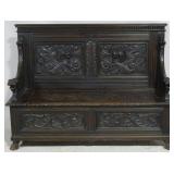 Griffin adorned heavily carved oak settle