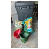 Garage garbage can with grass seed and spreaders.