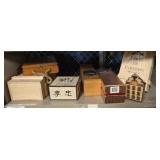 Assorted wood and cardboard boxes on one shelf.