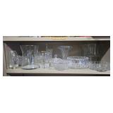 Glass vases and other dishes on one shelf. Some