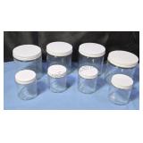 Glass storage jars with metal lids.