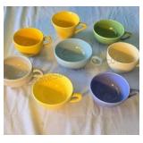 Assorted ceramic cups in various colors. No
