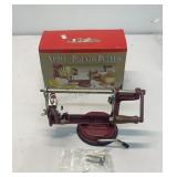 Apple-Potato Peeler with a red cast iron body.
