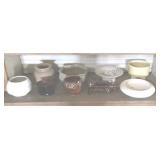 Assorted planters on one shelf.