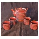 Glazed clay teapot with four cups.  Appears to be