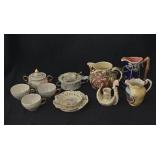 Assorted creamers, sugar bowls, tea cups, teabag